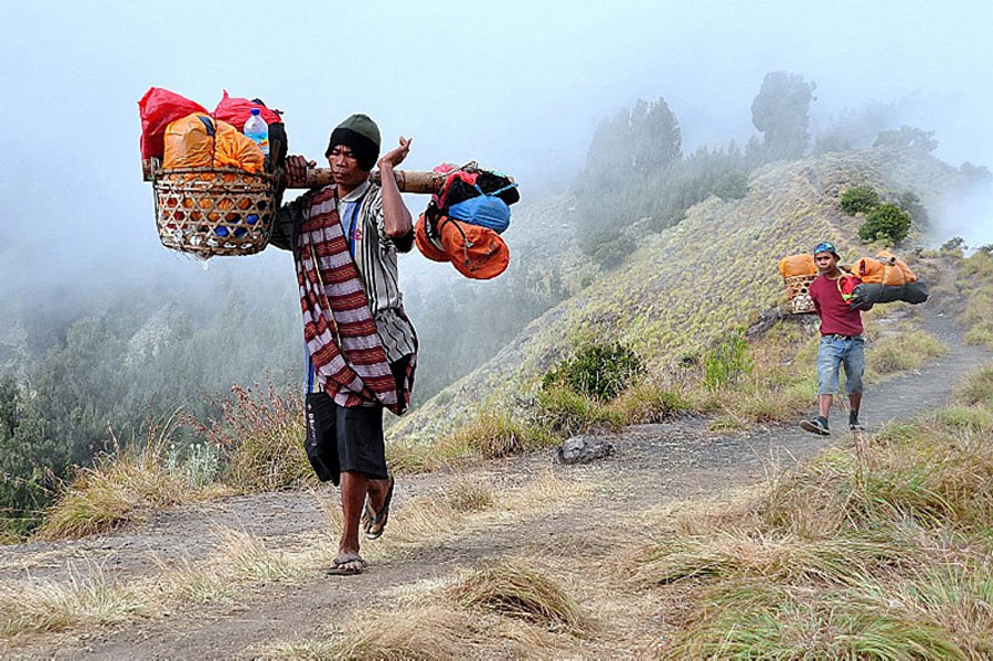 Burden on the shoulders of our porters during hiking to Mount Rinjani fit 20 kg